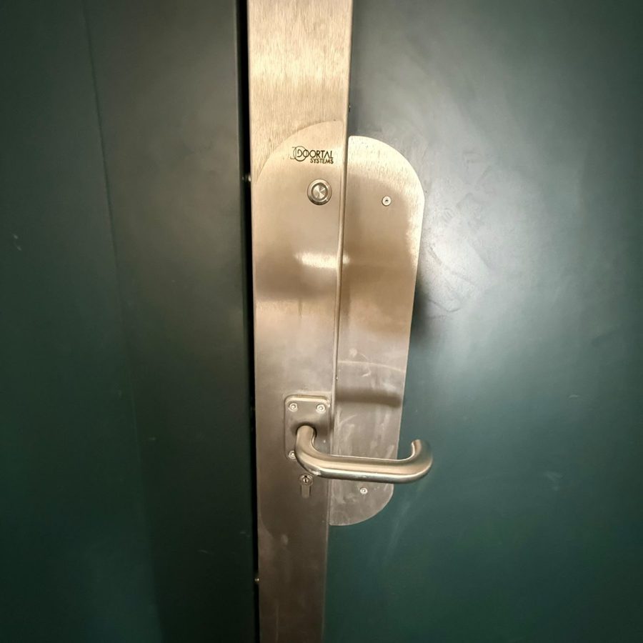 Serrure de sécurité en applique sur la porte verte d'un local professionnel