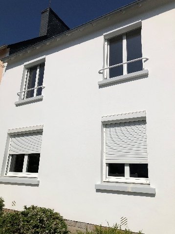 Volets roulants blancs sur une façade